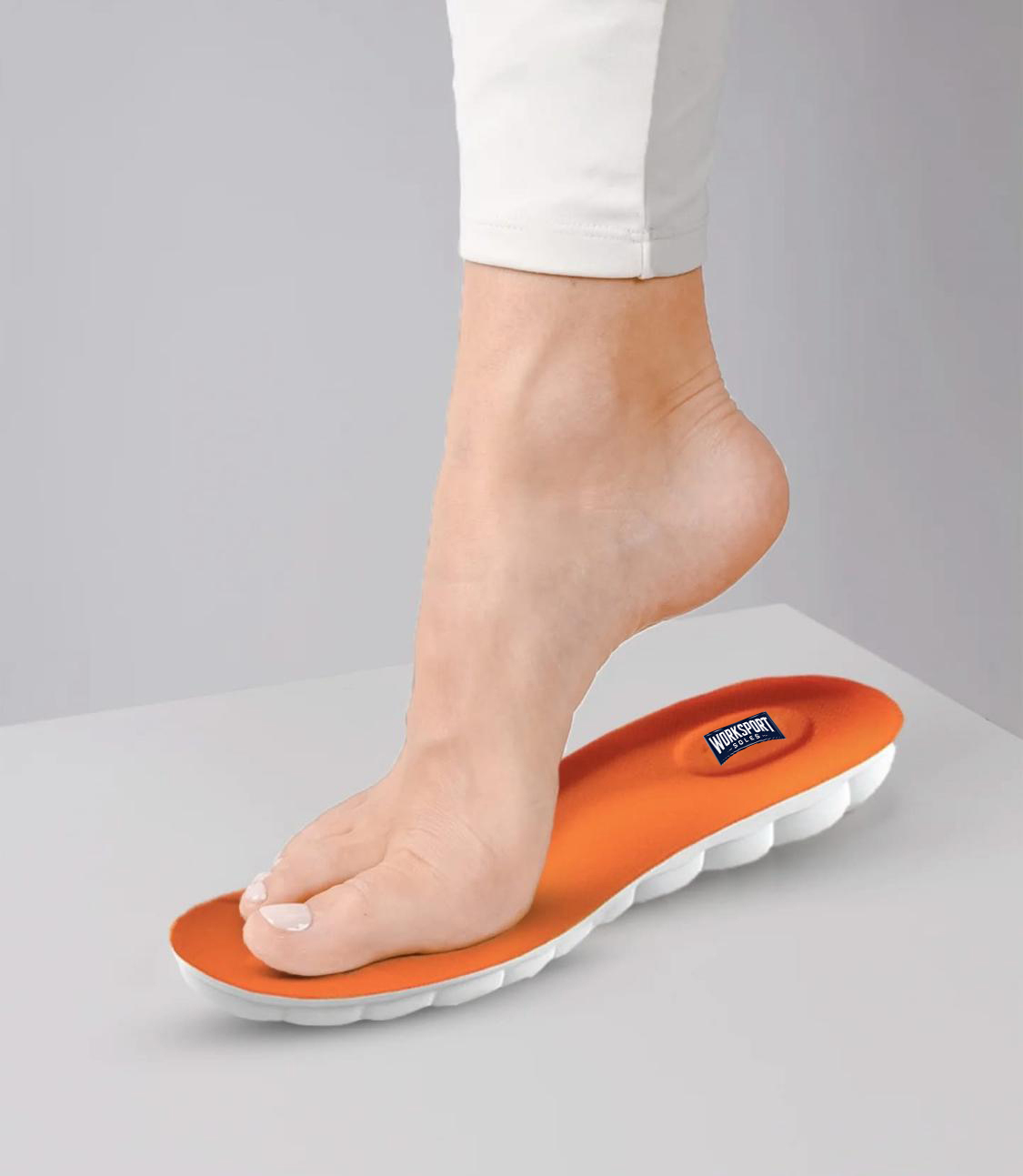 Foot stepping on an orange orthotic insole for arch support.