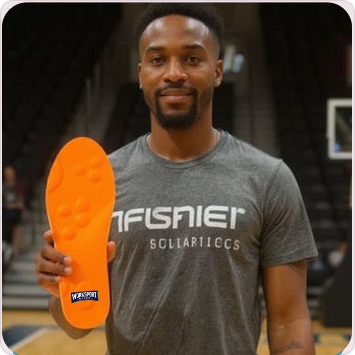 Man holding a bright orange insole and smiling.